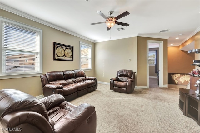 living room with light carpet, a healthy amount of sunlight, and ornamental molding