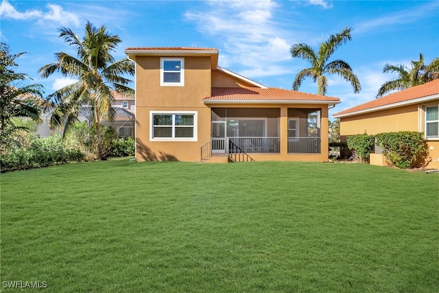 rear view of property with a sunroom and a yard