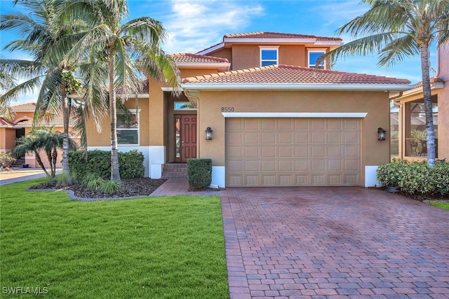 mediterranean / spanish-style home with a garage and a front lawn