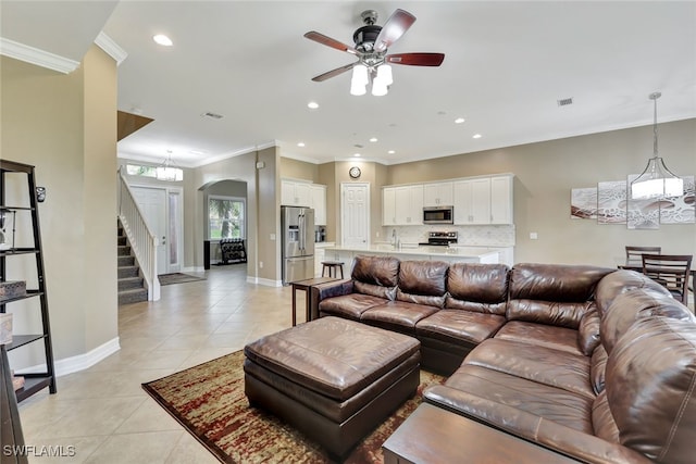 tiled living room featuring ceiling fan, sink, and crown molding