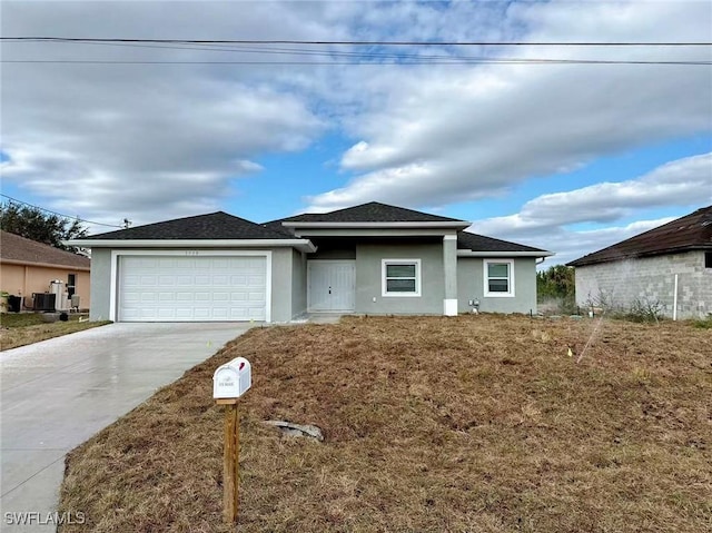 view of front of property with a garage, a front lawn, and central AC unit