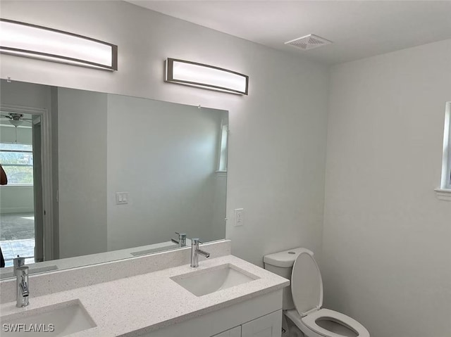 bathroom with toilet, ceiling fan, and vanity