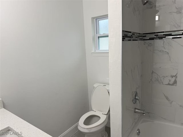 bathroom with tiled shower / bath combo and toilet