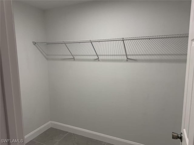 spacious closet featuring dark tile patterned flooring