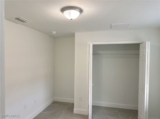 3708 15th St SW, Lehigh Acres, FL 33976 - unfurnished bedroom with a closet, light tile patterned floors, and baseboards