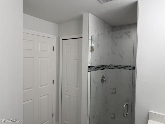 bathroom with a shower with door