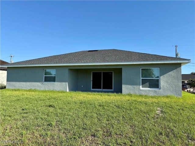 3708 15th St SW, Lehigh Acres, FL 33976 - back of property with stucco siding and a lawn