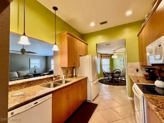 kitchen with white appliances, pendant lighting, light tile patterned floors, ceiling fan, and sink