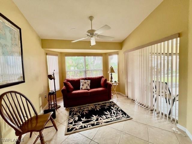 living room featuring lofted ceiling, ceiling fan, and light tile patterned floors