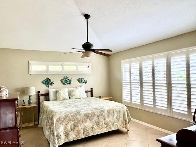 bedroom with ceiling fan and light tile patterned floors