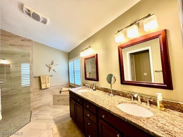 bathroom featuring vanity, tile patterned floors, and vaulted ceiling