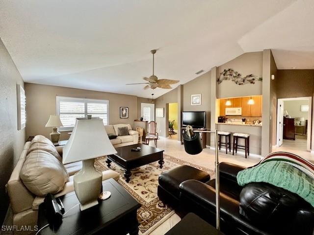 living room featuring ceiling fan and vaulted ceiling