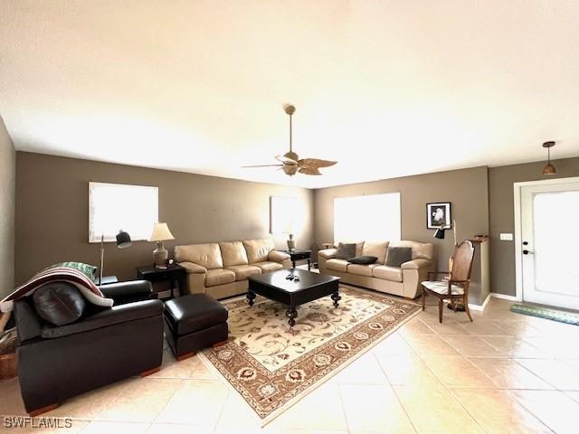 tiled living room with ceiling fan