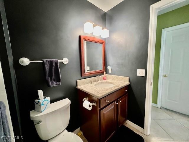 bathroom with toilet, tile patterned floors, and vanity