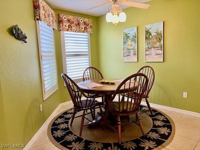 dining space with light tile patterned flooring and ceiling fan