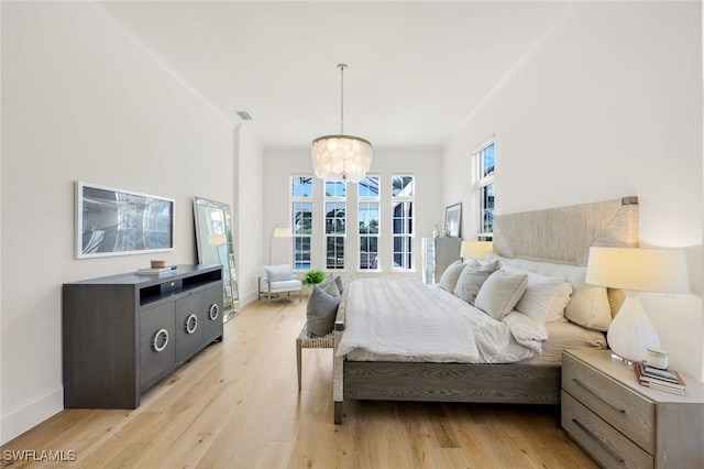 bedroom featuring light hardwood / wood-style flooring and a notable chandelier