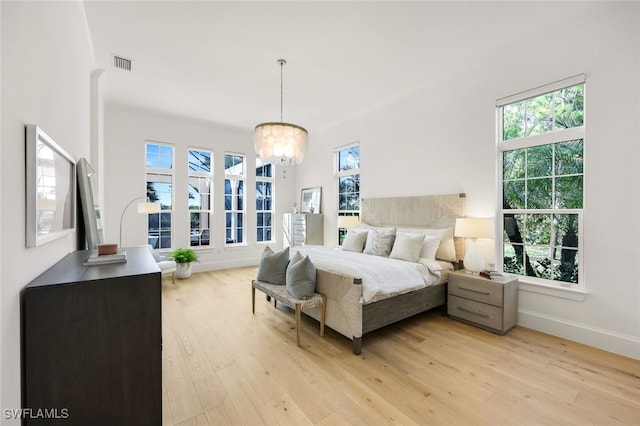 bedroom featuring light wood-type flooring and a notable chandelier