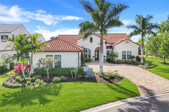 mediterranean / spanish-style home with a front lawn