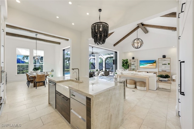 kitchen with light stone countertops, a healthy amount of sunlight, a kitchen island with sink, and pendant lighting