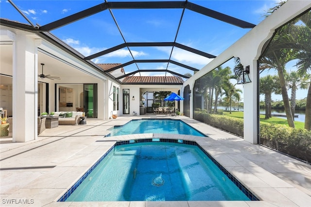 view of swimming pool featuring a lanai, a water view, outdoor lounge area, ceiling fan, and a patio area