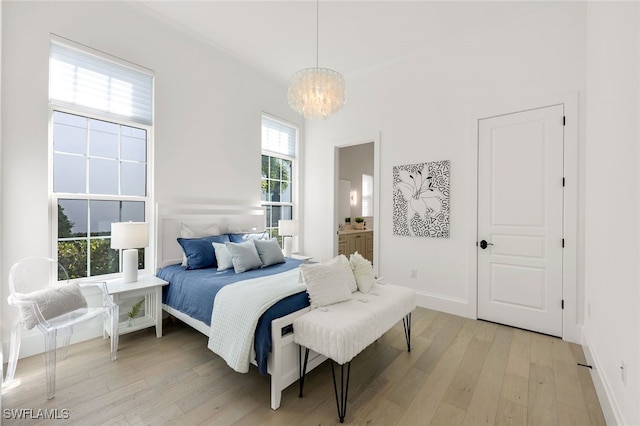 bedroom featuring light wood-type flooring and a chandelier