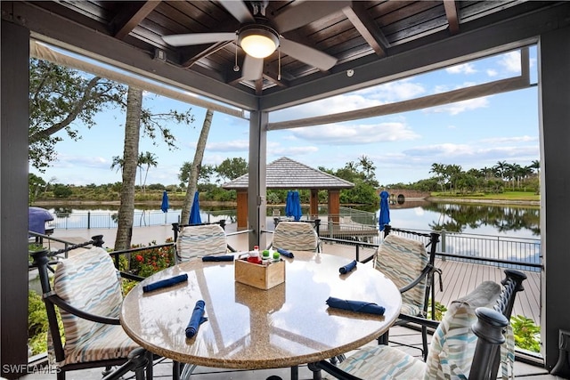 view of patio / terrace with ceiling fan, a water view, and a gazebo