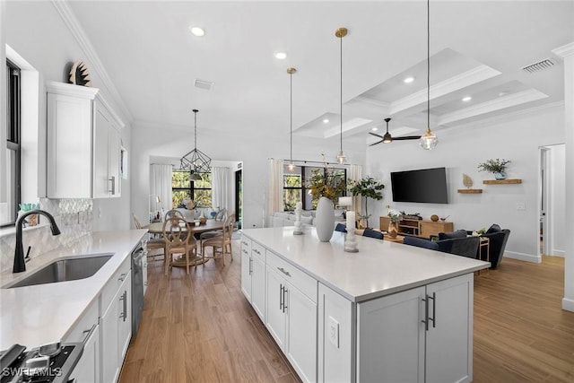 kitchen featuring sink, white cabinets, decorative light fixtures, ceiling fan, and a kitchen island