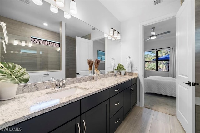 bathroom featuring tile patterned flooring, ceiling fan, tiled shower, and vanity