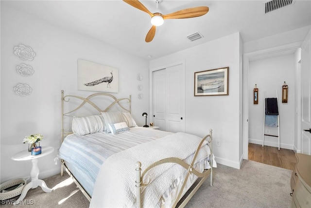 carpeted bedroom with ceiling fan and a closet