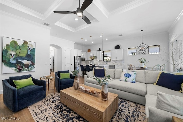 living room with coffered ceiling, ornamental molding, and beam ceiling