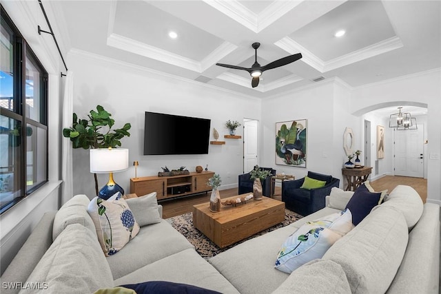 living room with beamed ceiling, crown molding, coffered ceiling, and ceiling fan with notable chandelier