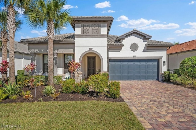 mediterranean / spanish-style home with a garage and a front lawn