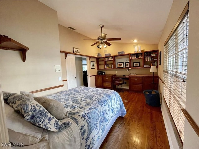 bedroom featuring lofted ceiling, dark wood-type flooring, built in desk, and ceiling fan