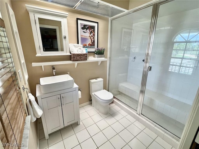 bathroom featuring vanity, tile patterned flooring, a shower with door, and toilet