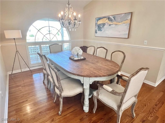 dining space with wood-type flooring and a chandelier