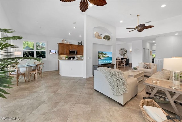 living room featuring a high ceiling and ceiling fan