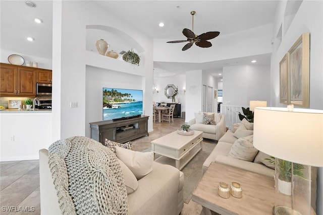 living room with a towering ceiling, ceiling fan, and sink