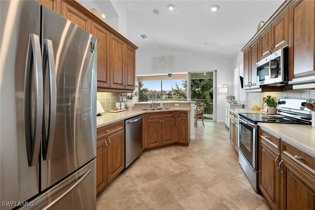 kitchen with stainless steel appliances, lofted ceiling, decorative backsplash, and sink