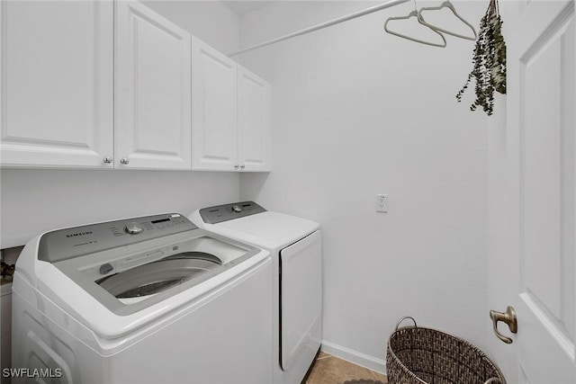 washroom with washing machine and dryer, tile patterned floors, and cabinets