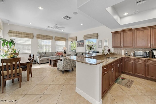 kitchen with ceiling fan, a wealth of natural light, light tile patterned floors, and kitchen peninsula