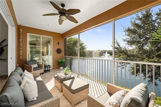 sunroom / solarium featuring ceiling fan and a water view