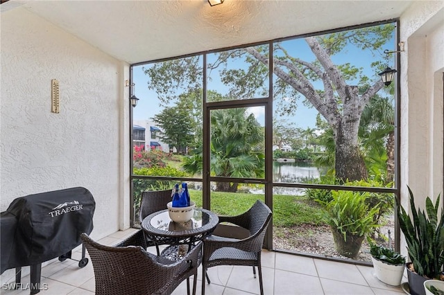 sunroom featuring a water view