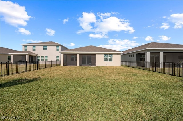 back of property with a yard and a sunroom