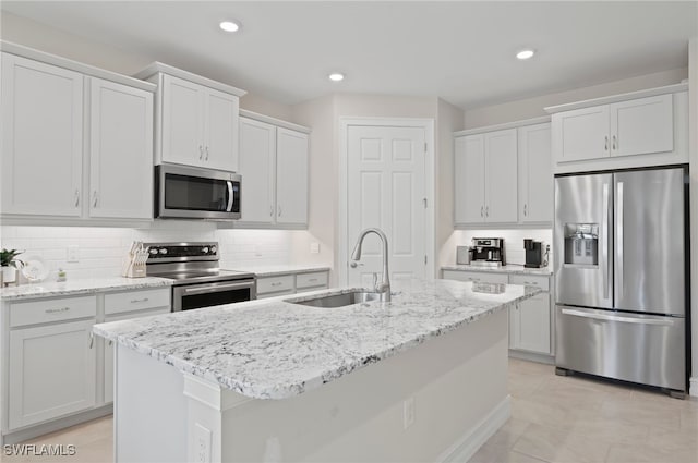 kitchen with stainless steel appliances, sink, a center island with sink, and white cabinets