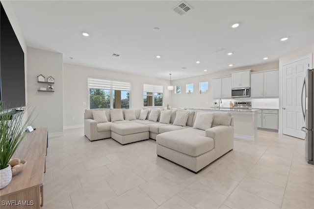 living room featuring sink and light tile patterned floors