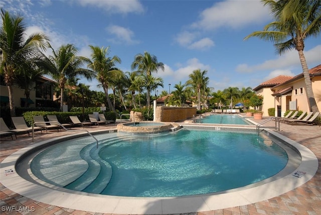 view of swimming pool featuring a community hot tub and a patio