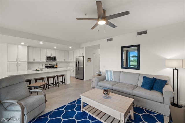 tiled living room with sink and ceiling fan