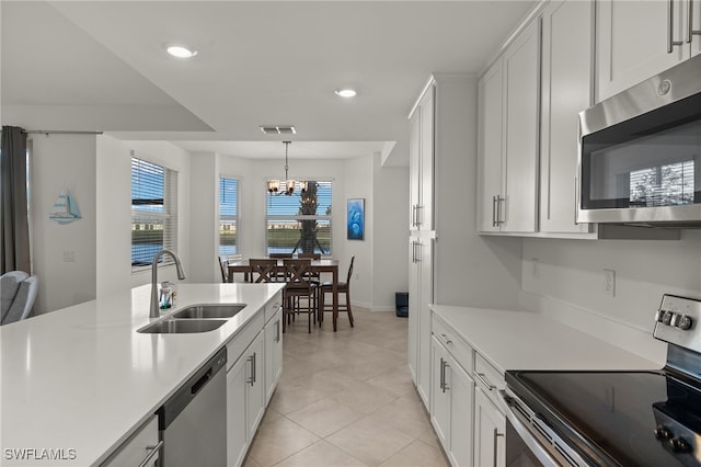 kitchen with stainless steel appliances, sink, and white cabinets