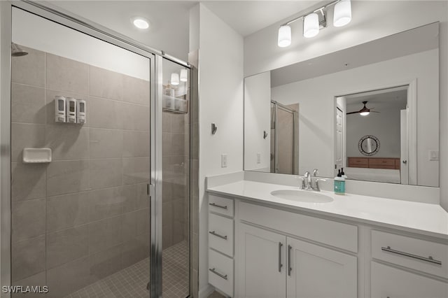 bathroom with walk in shower, ceiling fan, and vanity