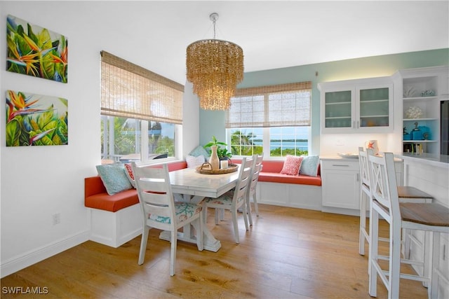 dining space with breakfast area, an inviting chandelier, and light hardwood / wood-style flooring